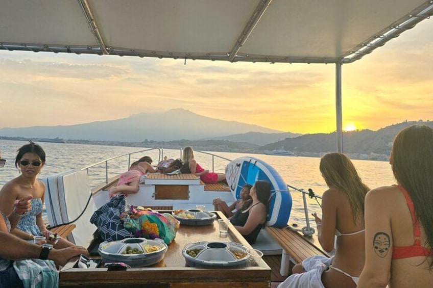 A group of people on a boat with a mountainous landscape in the background. 1