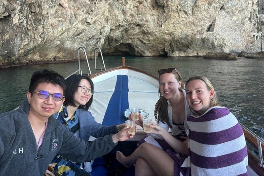 A group of people on a boat near rocky cliffs. 2