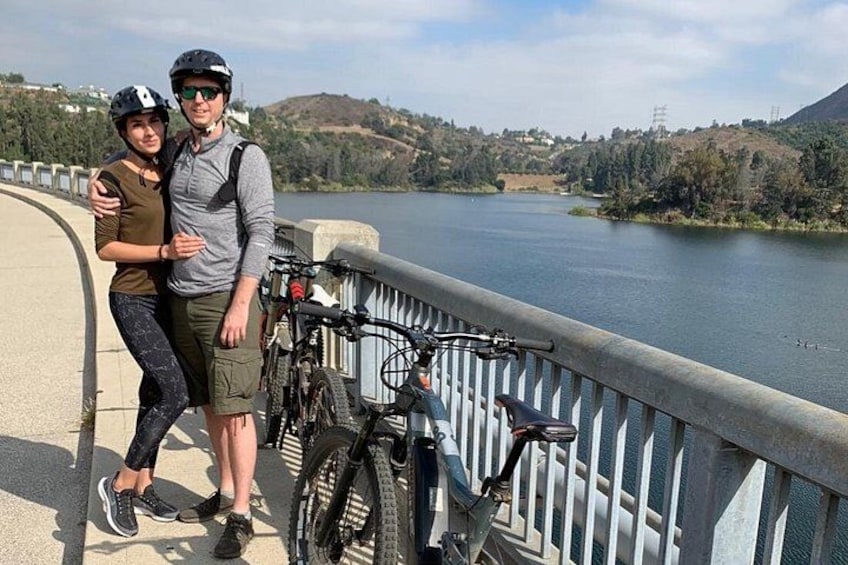 Un ponte con biciclette parcheggiate sul lato, un corso d'acqua e un paesaggio collinare sullo sfondo. 2
