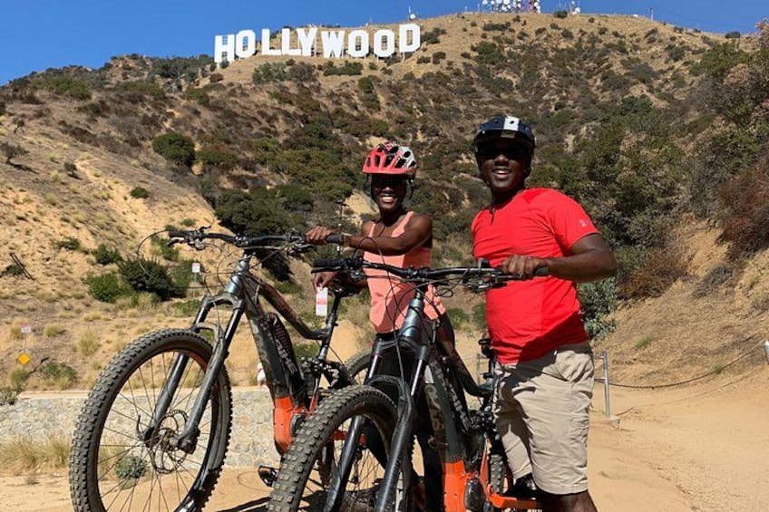 Due persone con biciclette davanti al cartello di Hollywood. 5