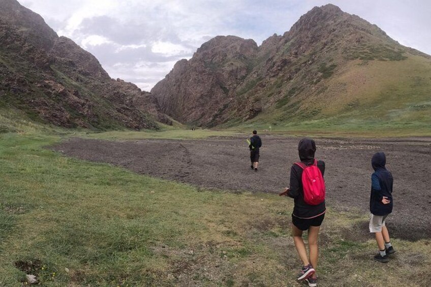 A group of hikers on a trail with mountains in the background. 5