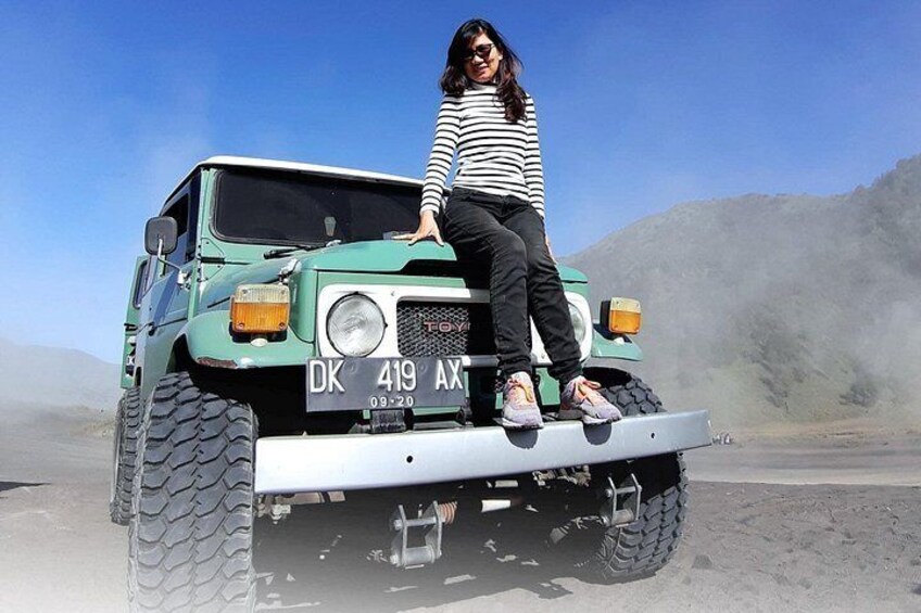 A person sitting on a green off-road vehicle with a license plate DK 419 AX. 3