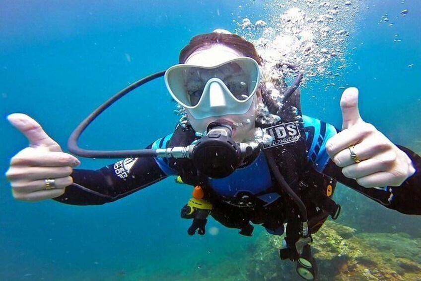 A scuba diver underwater giving a thumbs-up. 5