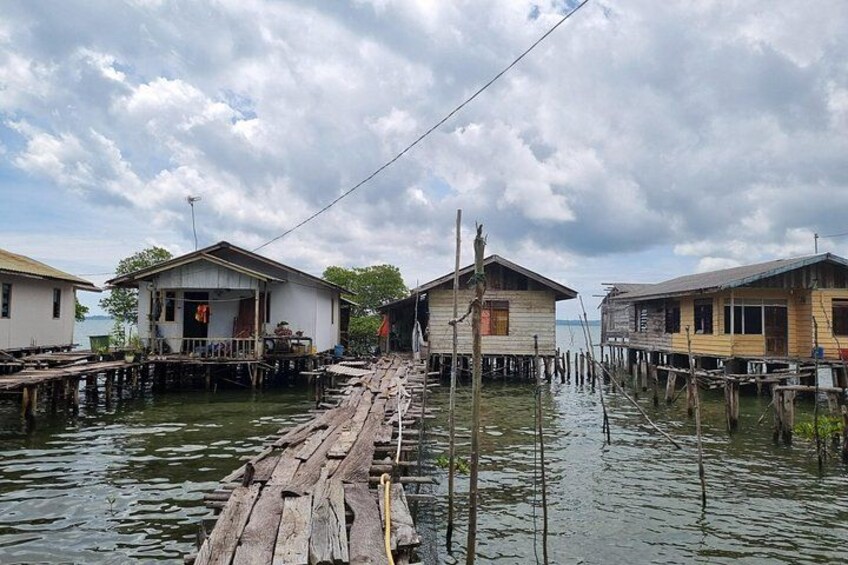 A wooden walkway connecting houses over water. 4