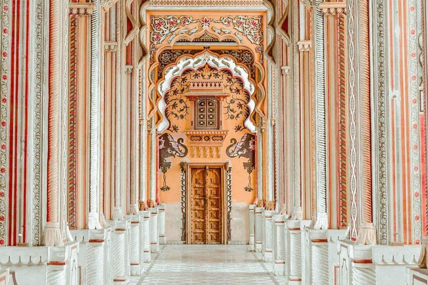 An ornate corridor with intricate patterns and a central door. 4