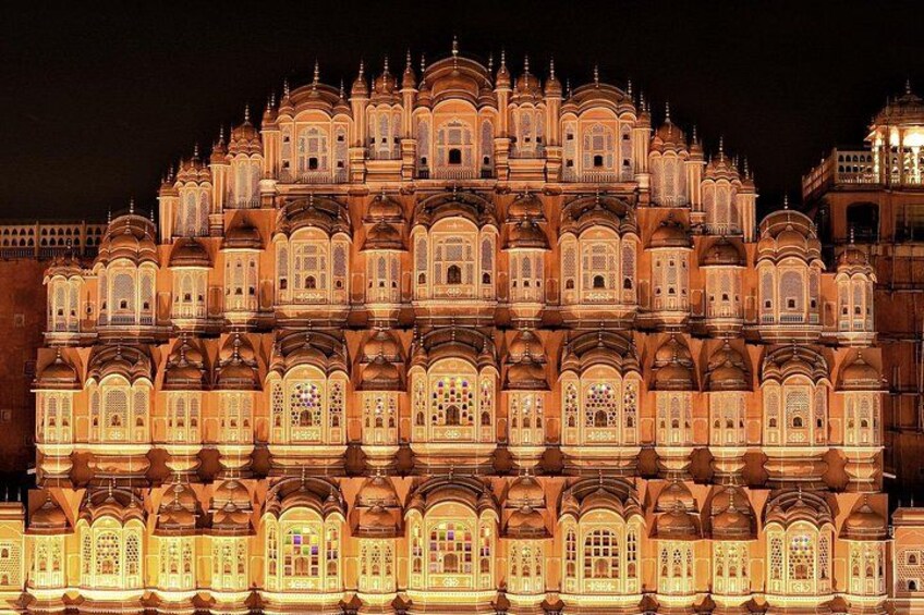 A brightly lit, multi-tiered building with ornate windows and domes. 3