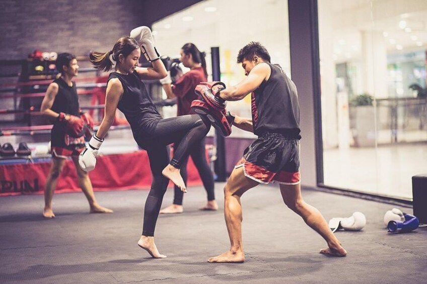 A martial arts training session with participants practicing kicks and punches. 2