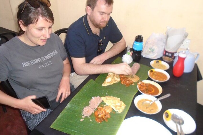 Two people sitting at a table with various dishes, including rice and curry, and a smartphone. 5