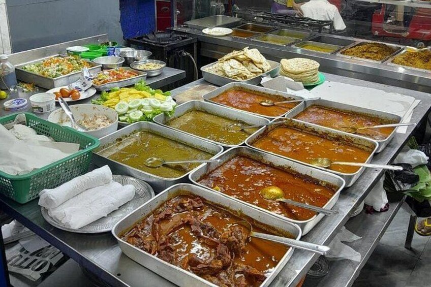 A buffet with various dishes, including curries and salads. 2
