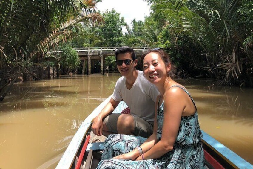 Two people in a boat on a river surrounded by dense vegetation. 2