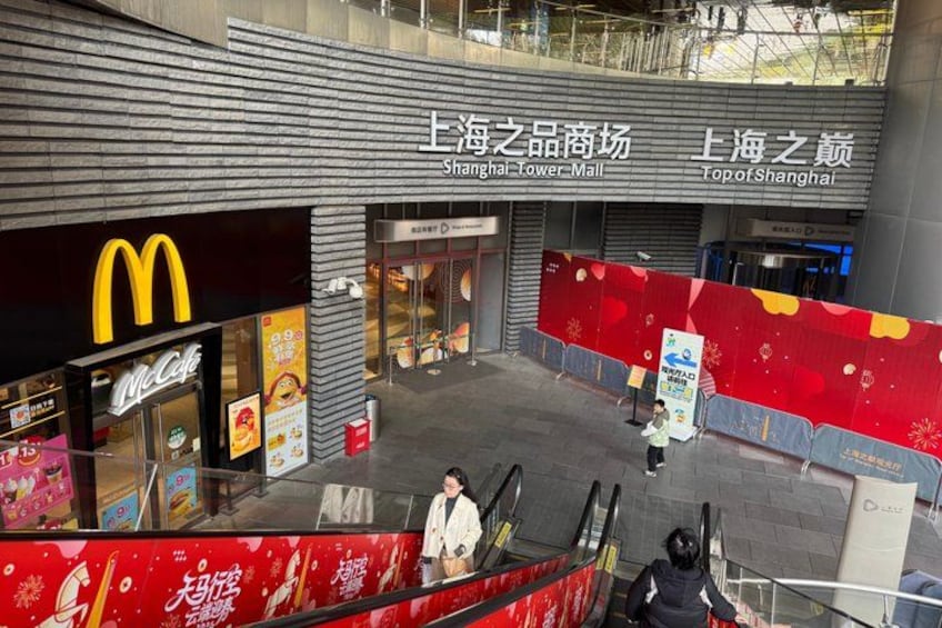 A shopping mall interior with a McDonald's restaurant, escalators, and signage in a foreign language. 4