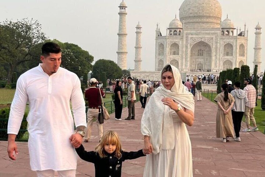 A family walking in front of the Taj Mahal. 1