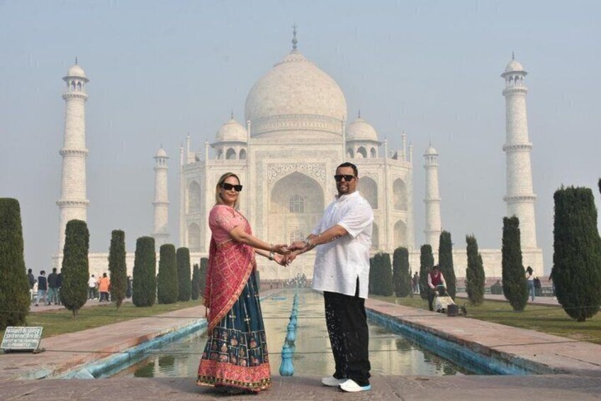 A couple holding hands in front of the Taj Mahal. 5