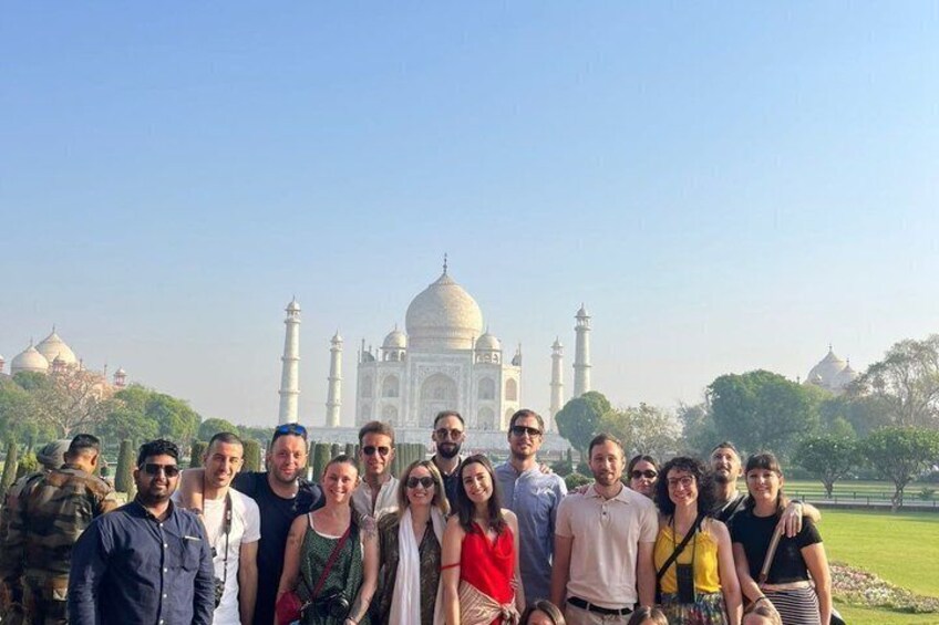 A group of people standing in front of the Taj Mahal. 4