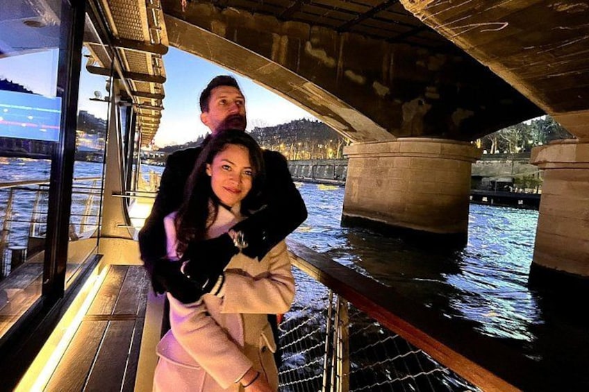 A boat with a person being carried on the deck, water, and a bridge in the background. 1