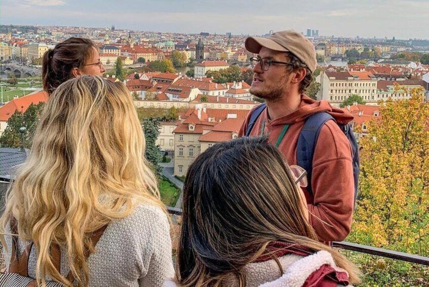 A group of people standing on a hill overlooking a cityscape with red-roofed buildings. 4