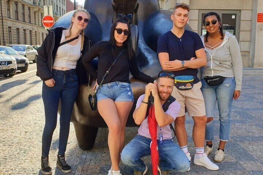 A group of people posing in front of a large sculpture. 1