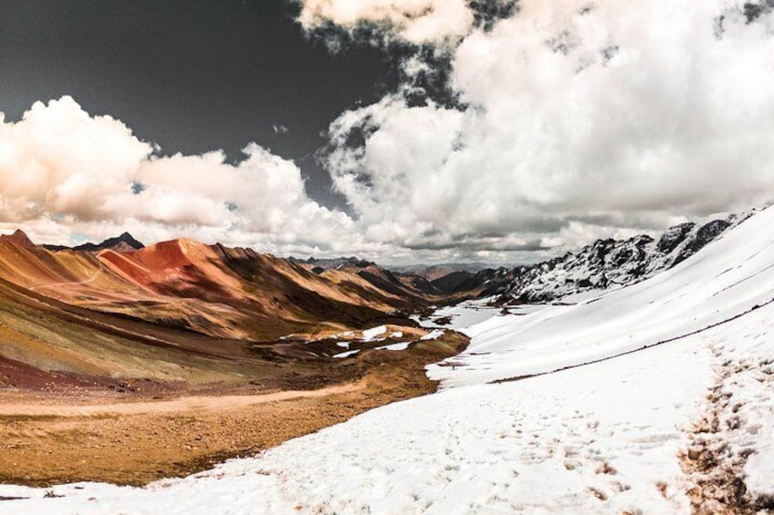 A snow-covered mountain landscape with colorful rock formations and a river. 2