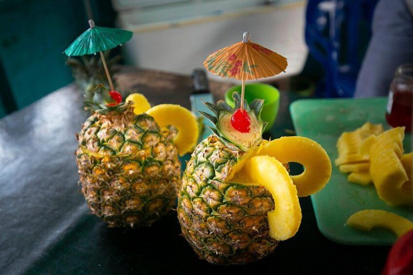 Two decorated pineapples with umbrellas and cherries on a table. 4