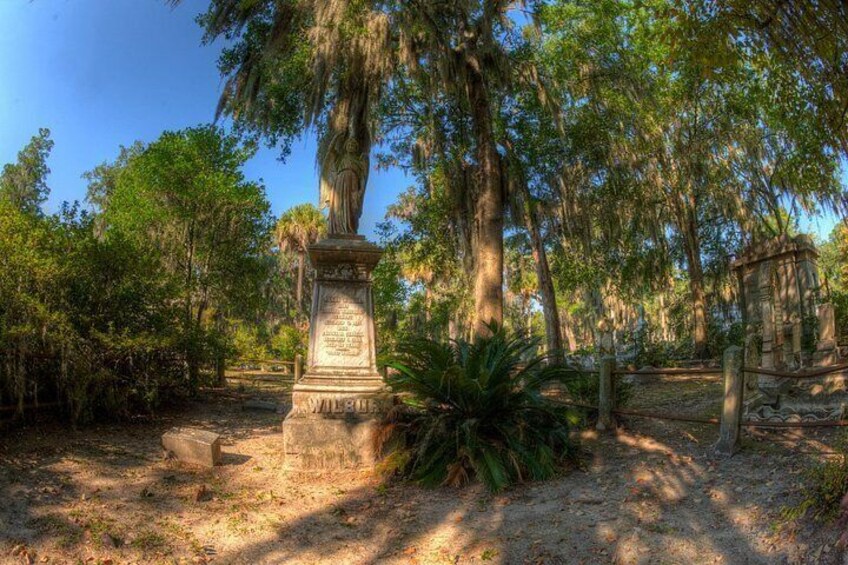 A historical monument surrounded by trees and a wooden fence. 5