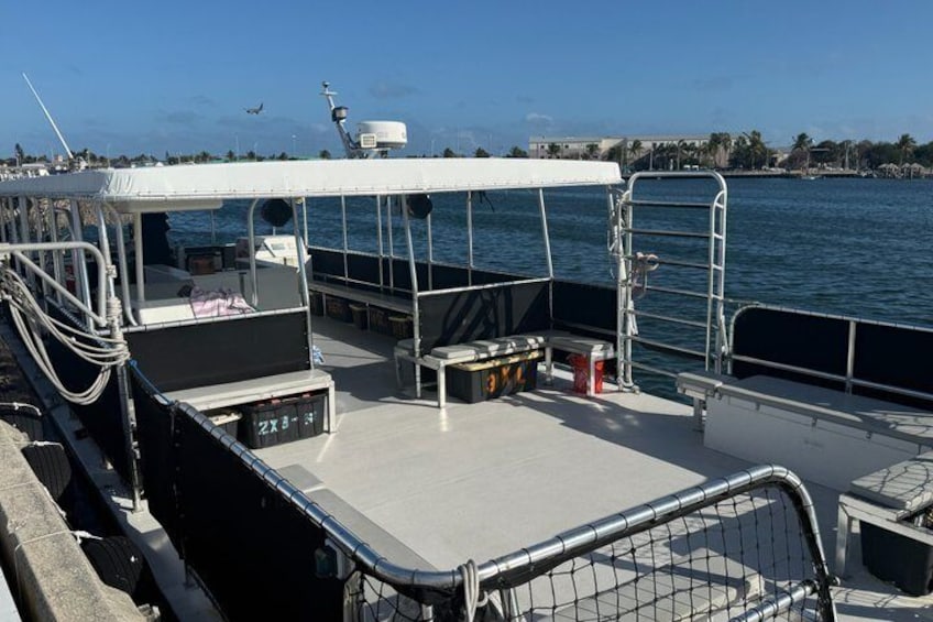 Cubierta de barco con toldo blanco, barandillas de metal y una escalera. 2