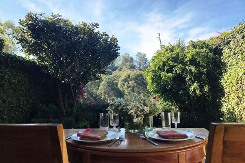 Una mesa de madera con un plato de comida y un jarrón de flores. 1
