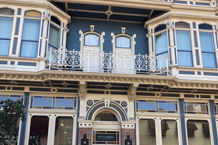 A building with ornate architectural details, including a balcony with intricate railings and large windows. 3