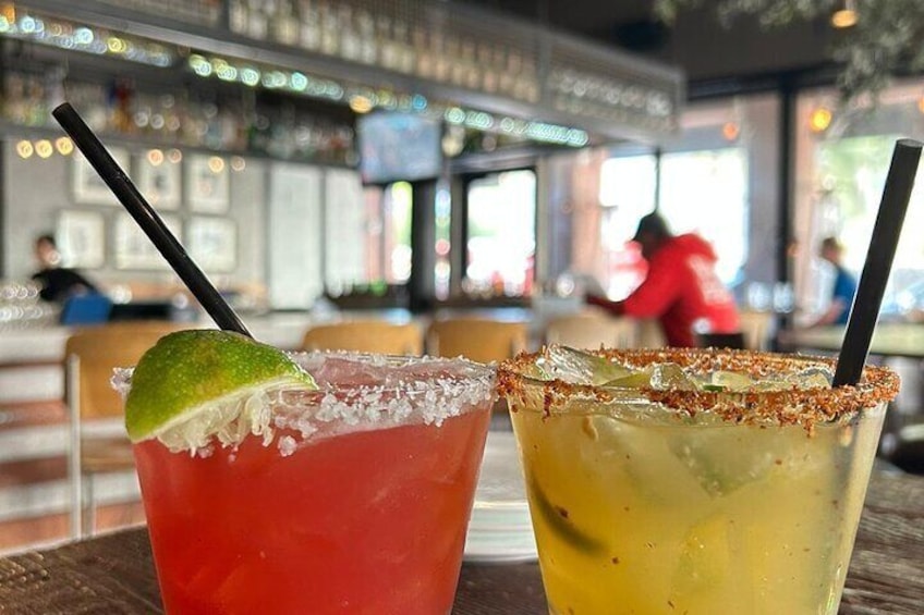 Two cocktails with lime garnishes on a bar counter. 5