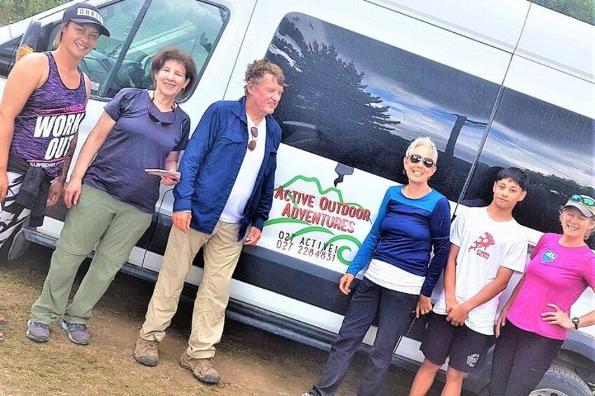 A group of people standing in front of a van with a 'Active Outdoor Adventures' logo. 3