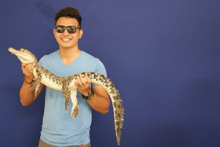 Une personne tenant un grand alligator. 2