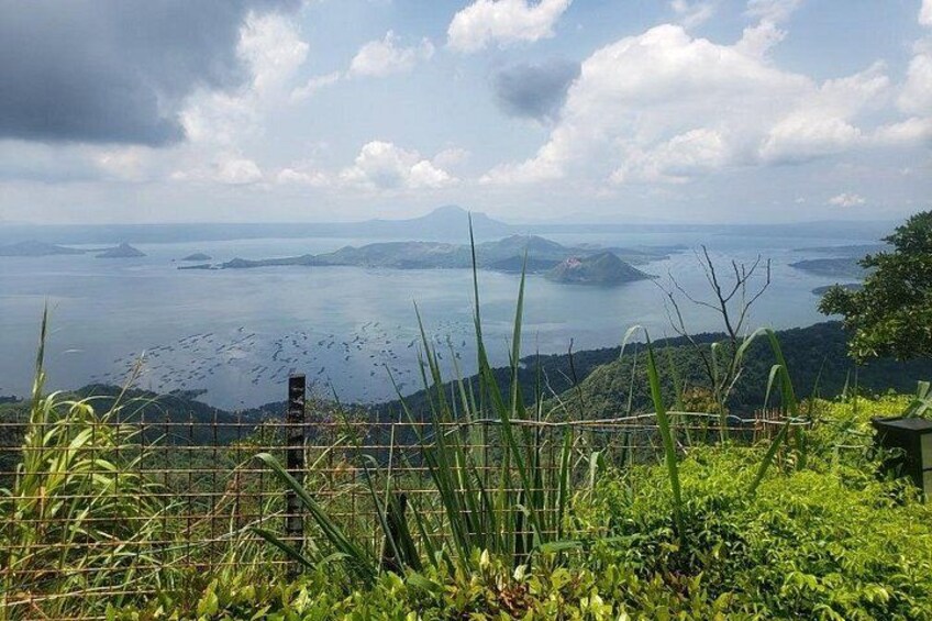 A coastal landscape with a view of the sea, distant islands, and a mountain in the background. 1