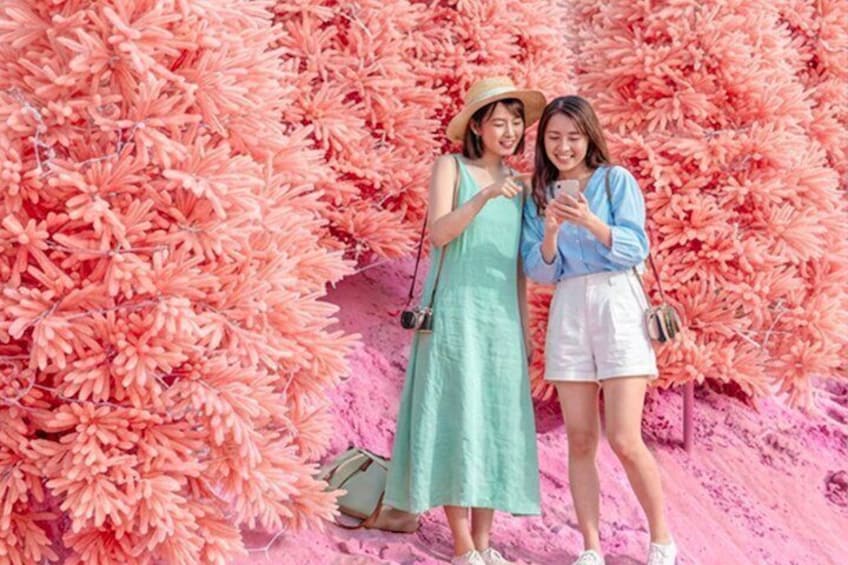 Two people standing in front of a pink floral backdrop. 3