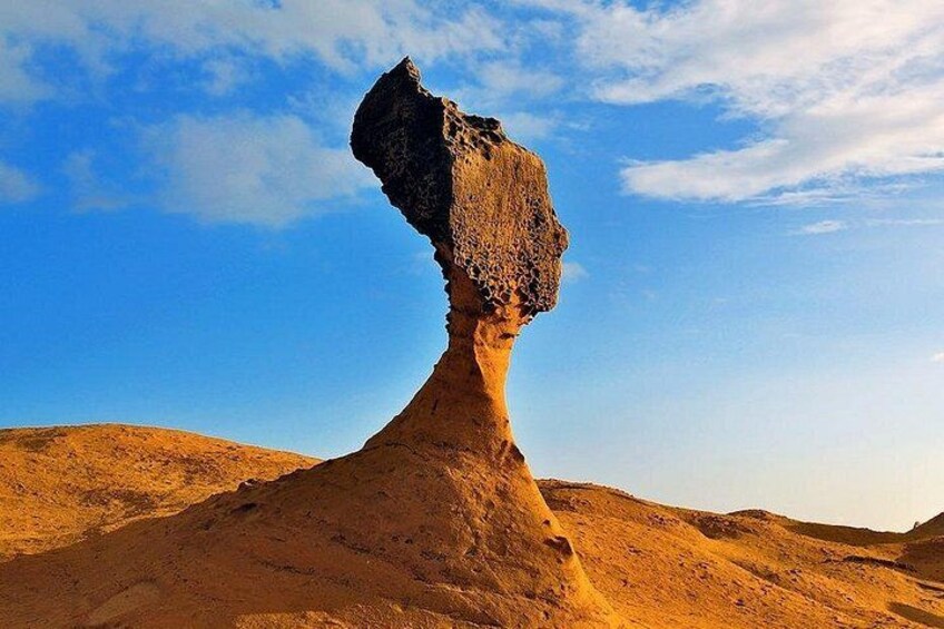 A rock formation resembling a human face in a desert landscape. 4