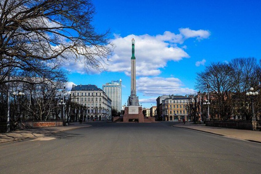A monument in a city square with buildings in the background. 5
