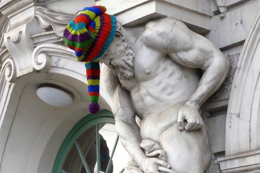 A statue of a muscular figure with a colorful knitted hat. 1