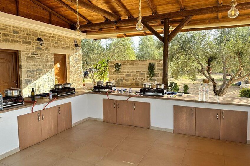 An outdoor kitchen with stone walls, wooden cabinets, and hanging lights. 4