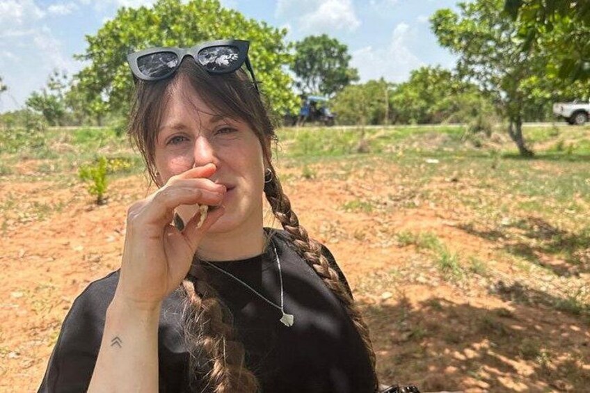 A person with sunglasses and a braided hairstyle in a natural outdoor setting. 5