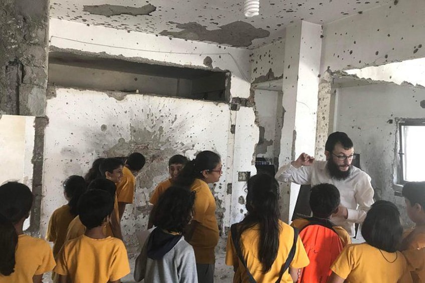A group of people in a damaged building with exposed walls and ceiling. 3