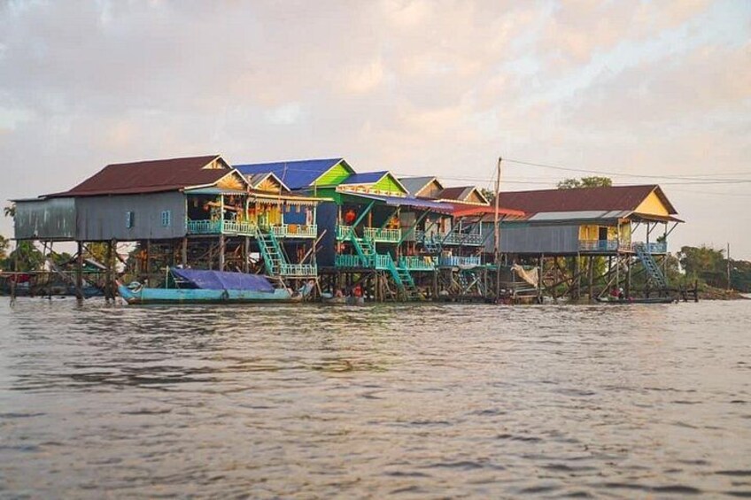 A floating house complex on water with multiple levels and colorful roofs. 3