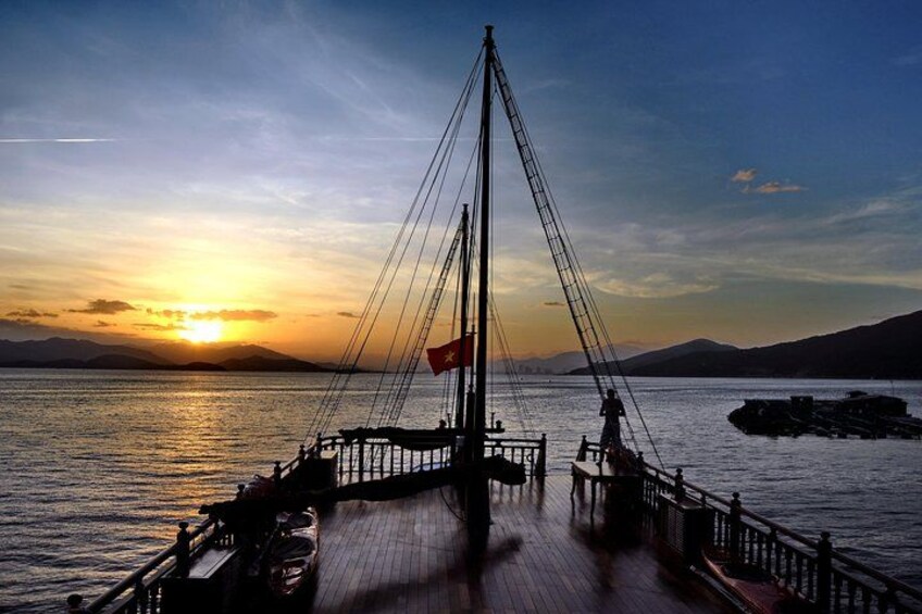 Eine Steg, der sich in ruhiges Wasser bei Sonnenuntergang erstreckt, mit einer Flagge am Mast. 4