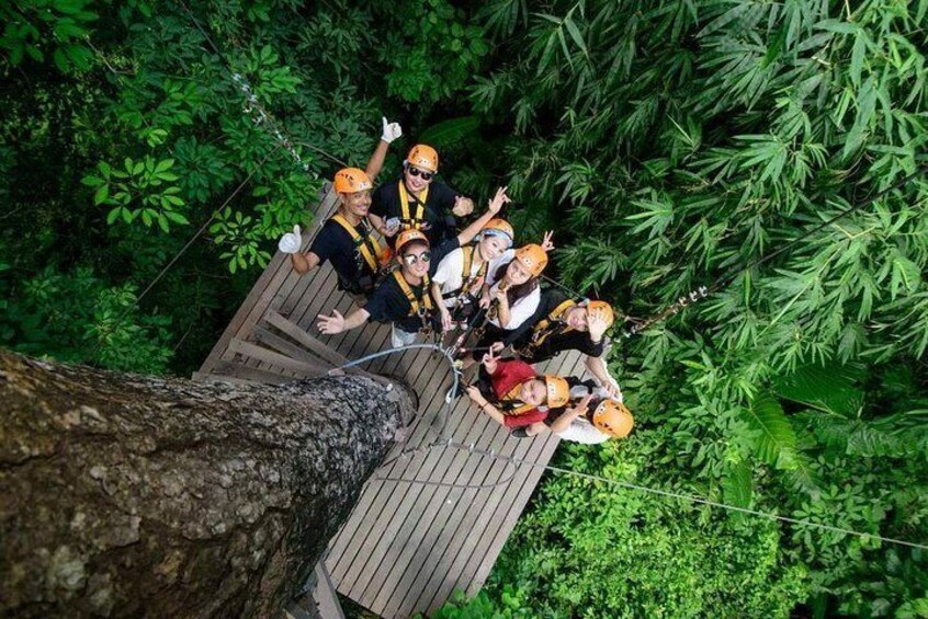 A group of people on a wooden platform in a forest. 4
