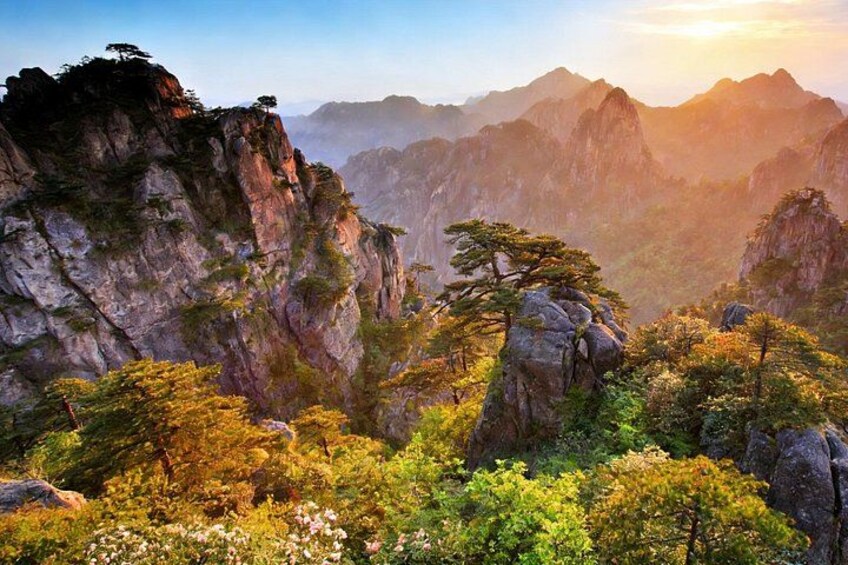 A mountainous landscape with rocky cliffs and dense vegetation. 2