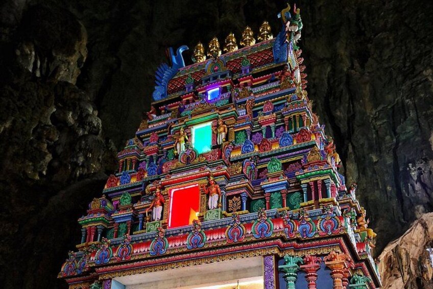 A brightly lit temple with intricate carvings and colorful decorations, set against a cave backdrop. 4