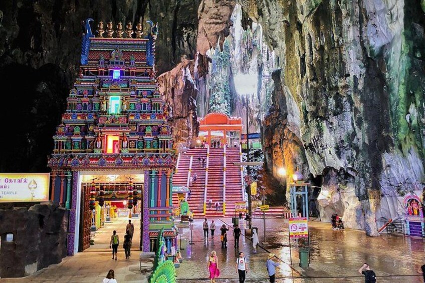 A temple with colorful architecture and a large rock formation in the background. 5