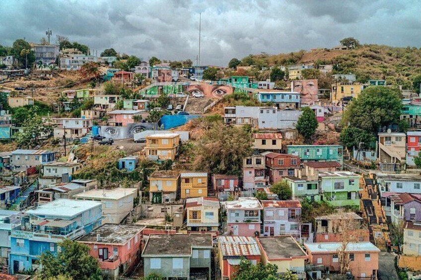 A densely packed hillside settlement with colorful houses and a winding road. 3