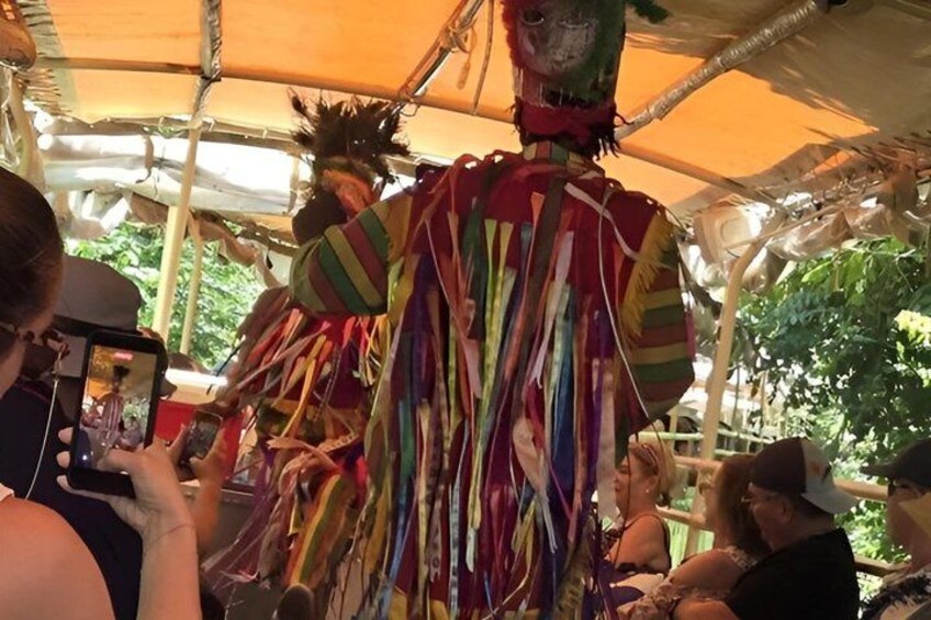 A colorful, multi-tiered structure with a person in a striped costume at the top, possibly part of a festival or event. 2