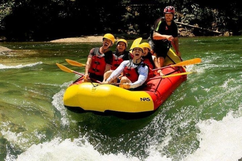 A group of people in a yellow and red raft on a river. 1