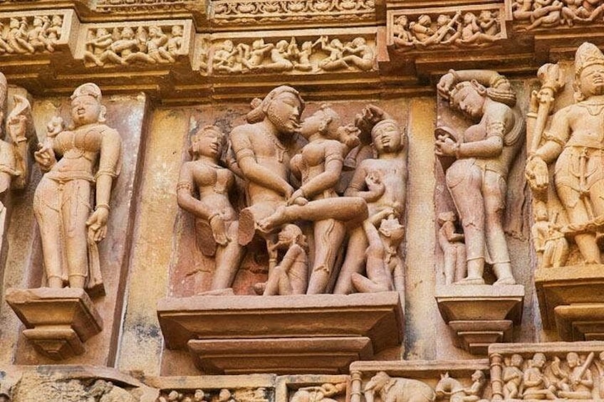 A detailed stone carving with multiple figures, including a central figure being supported by others, and a standing figure on the right. 2