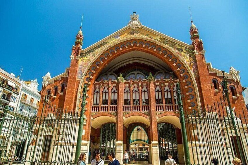 A large, ornate building with a red facade, arched windows, and decorative elements. 3