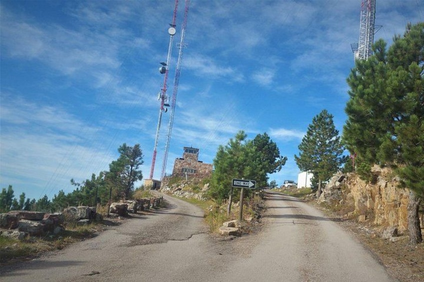 Una strada di campagna con un segnale stradale, una gru edile e un edificio sullo sfondo. 4